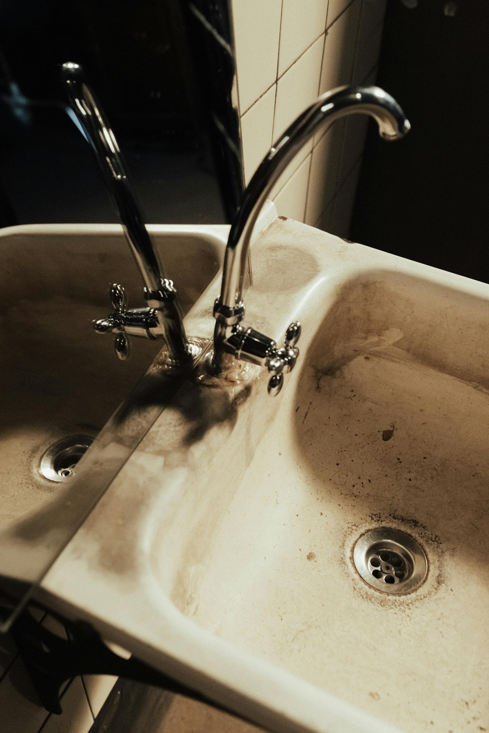 a neglected bathroom sink with visible dirt and a faucet reflection in the mirror 10473680 scaled 1
