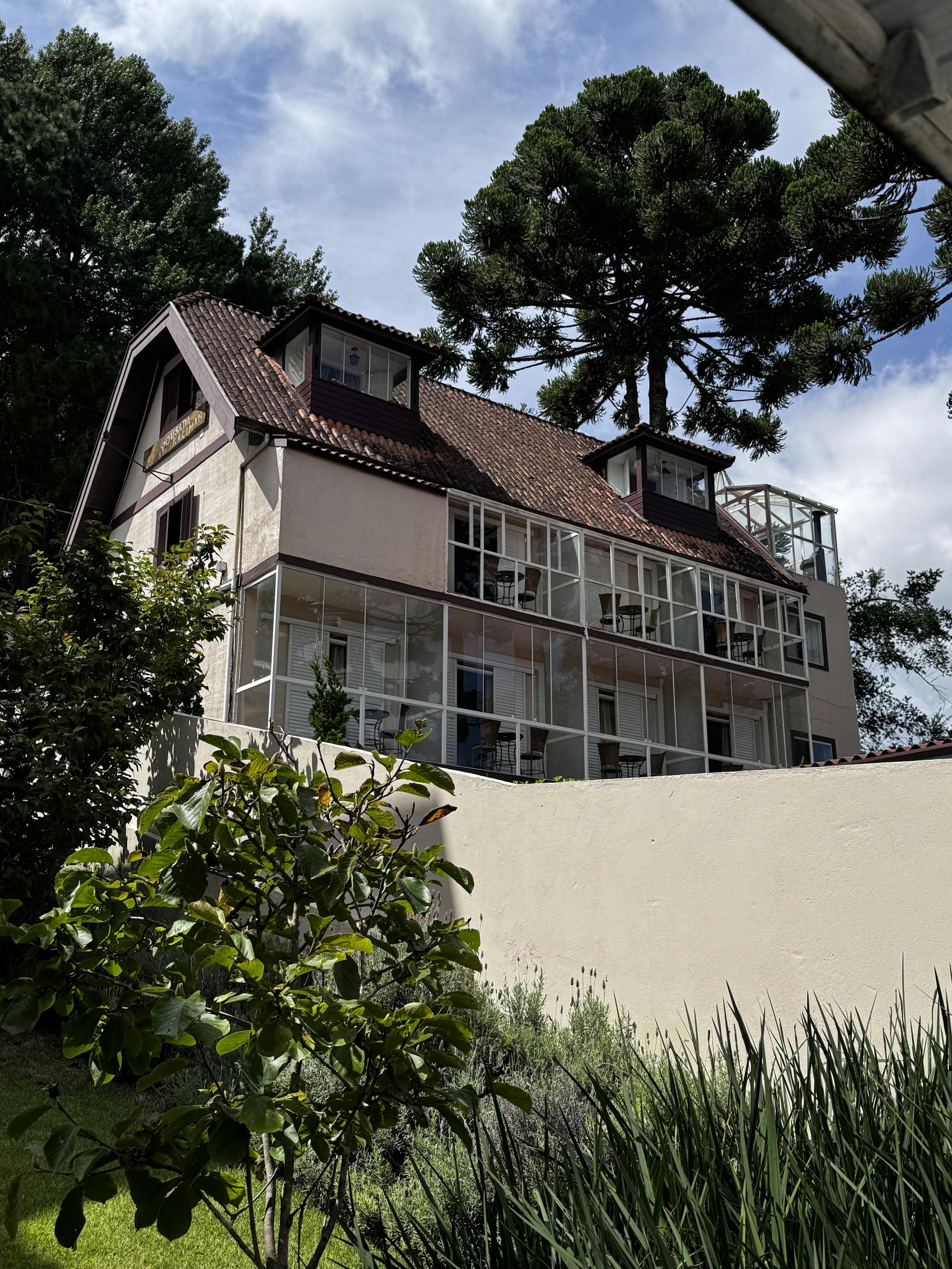quaint european style house with glass windows set in a lush garden under a blue sky 33690141 scaled 1
